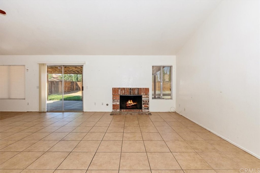 14560 Juniper Lane Adelanto, CA 92301 - Photo 5 of 25 an empty room with windows and fireplace