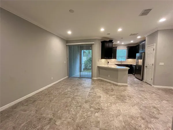 a view of kitchen with stainless steel appliances a refrigerator sink and white cabinets