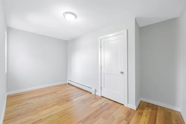 an empty room with wooden floor and closet