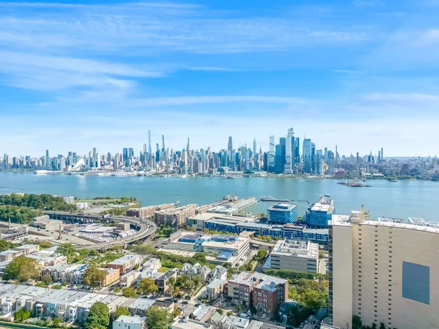 a kitchen with stainless steel appliances a stove a microwave oven cabinets and a wooden floor