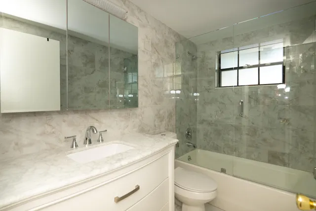 a bathroom with a bathtub shower sink vanity and toilet