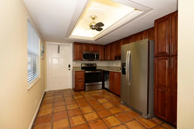 a kitchen with stainless steel appliances granite countertop a refrigerator and a stove top oven