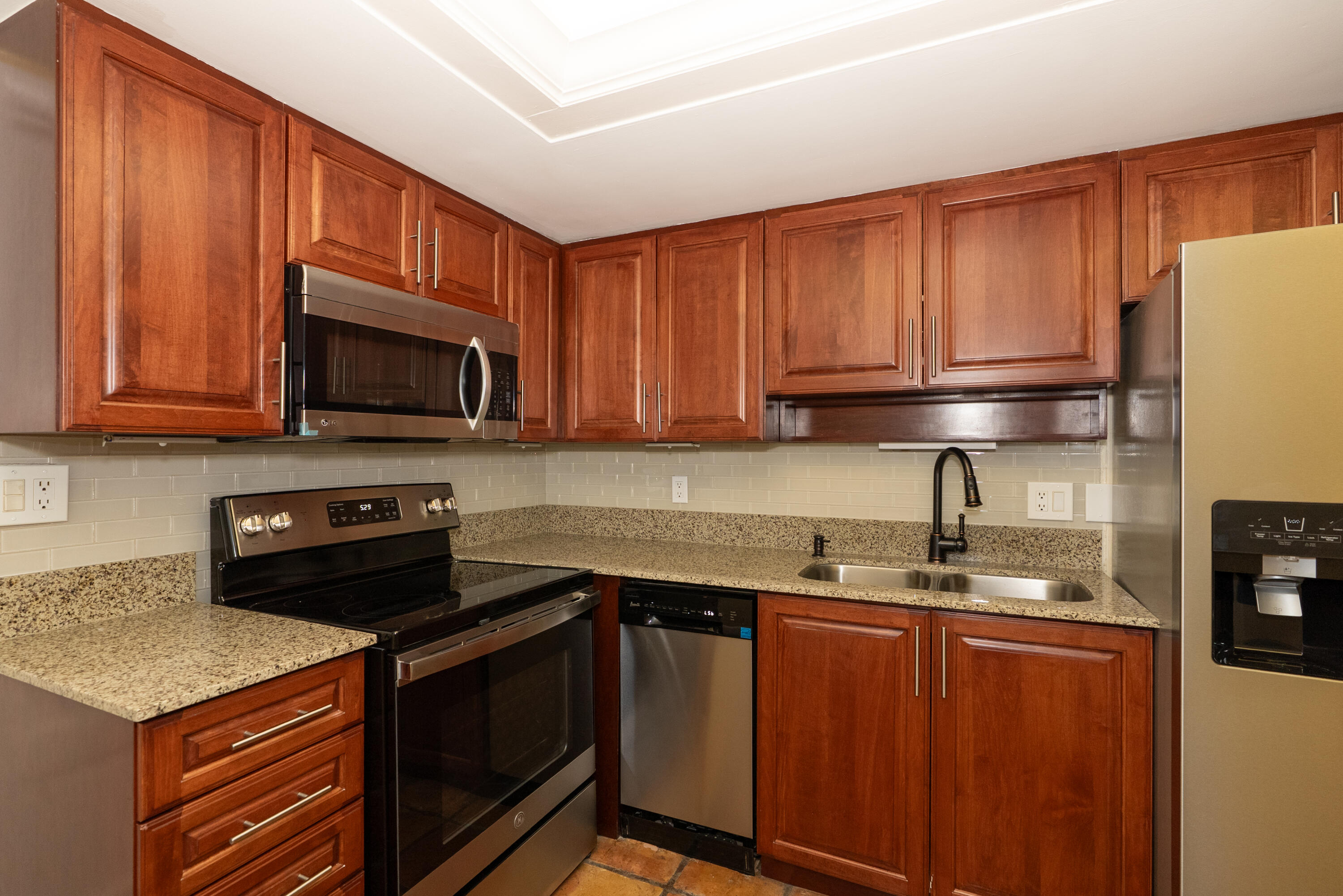 300 Inlet Way, Unit 2 Palm Beach Shores, FL 33404 - Photo 4 of 18 a kitchen with stainless steel appliances granite countertop a refrigerator stove top oven a sink and dishwasher