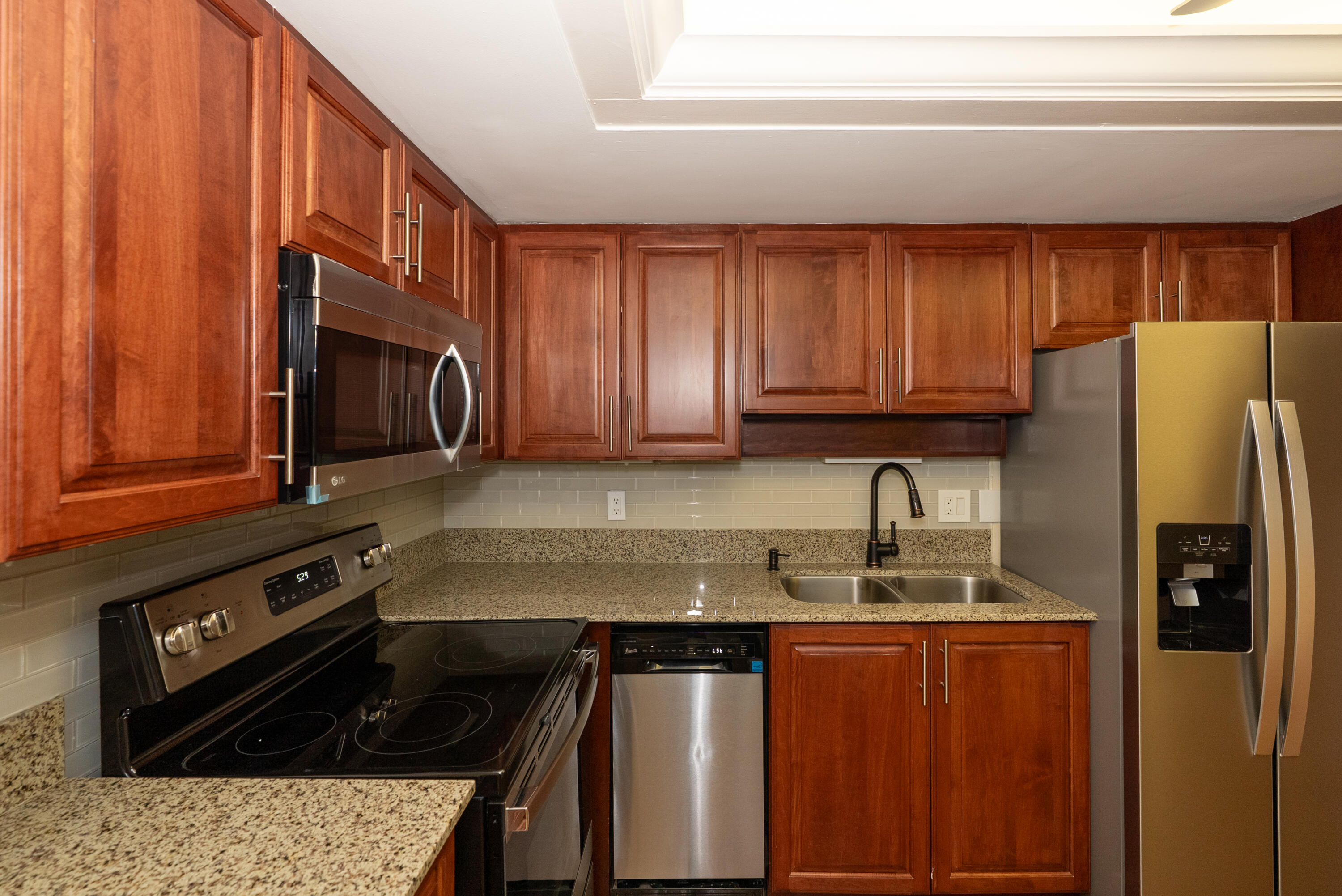 300 Inlet Way, Unit 2 Palm Beach Shores, FL 33404 - Photo 5 of 18 a kitchen with stainless steel appliances granite countertop a refrigerator stove and sink
