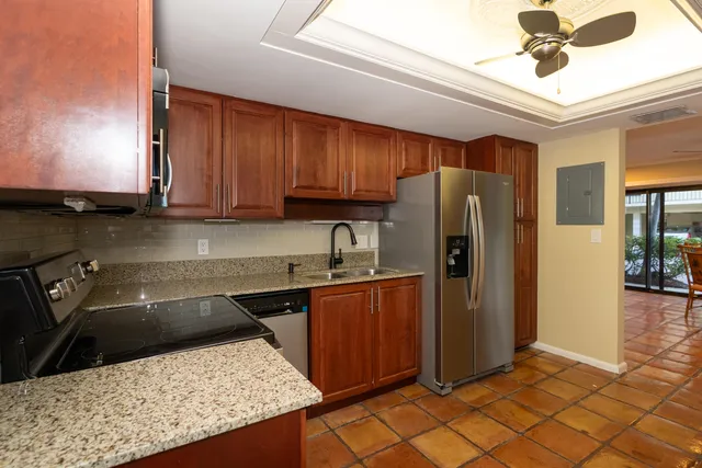 a kitchen with stainless steel appliances granite countertop a refrigerator a sink and dishwasher