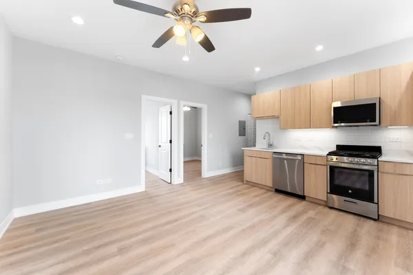 a kitchen with stainless steel appliances a stove top oven a sink and a refrigerator