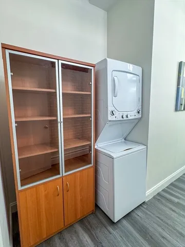 a utility room with wooden floor washer and dryer