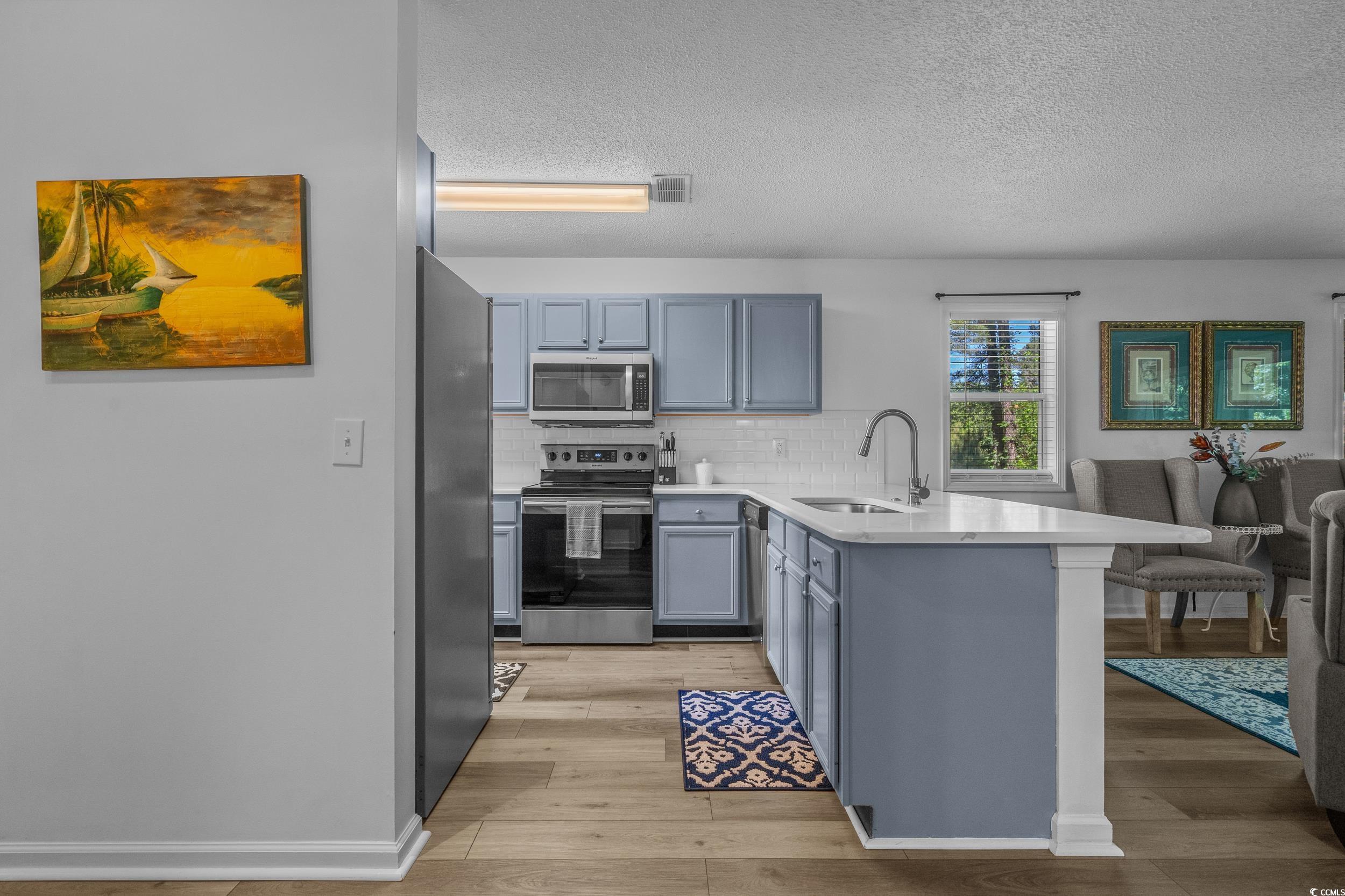 1290 White Tree Lane Myrtle Beach, SC 29588 - Photo 11 of 33 Living area with a textured ceiling, ceiling fan, and light wood-style flooring