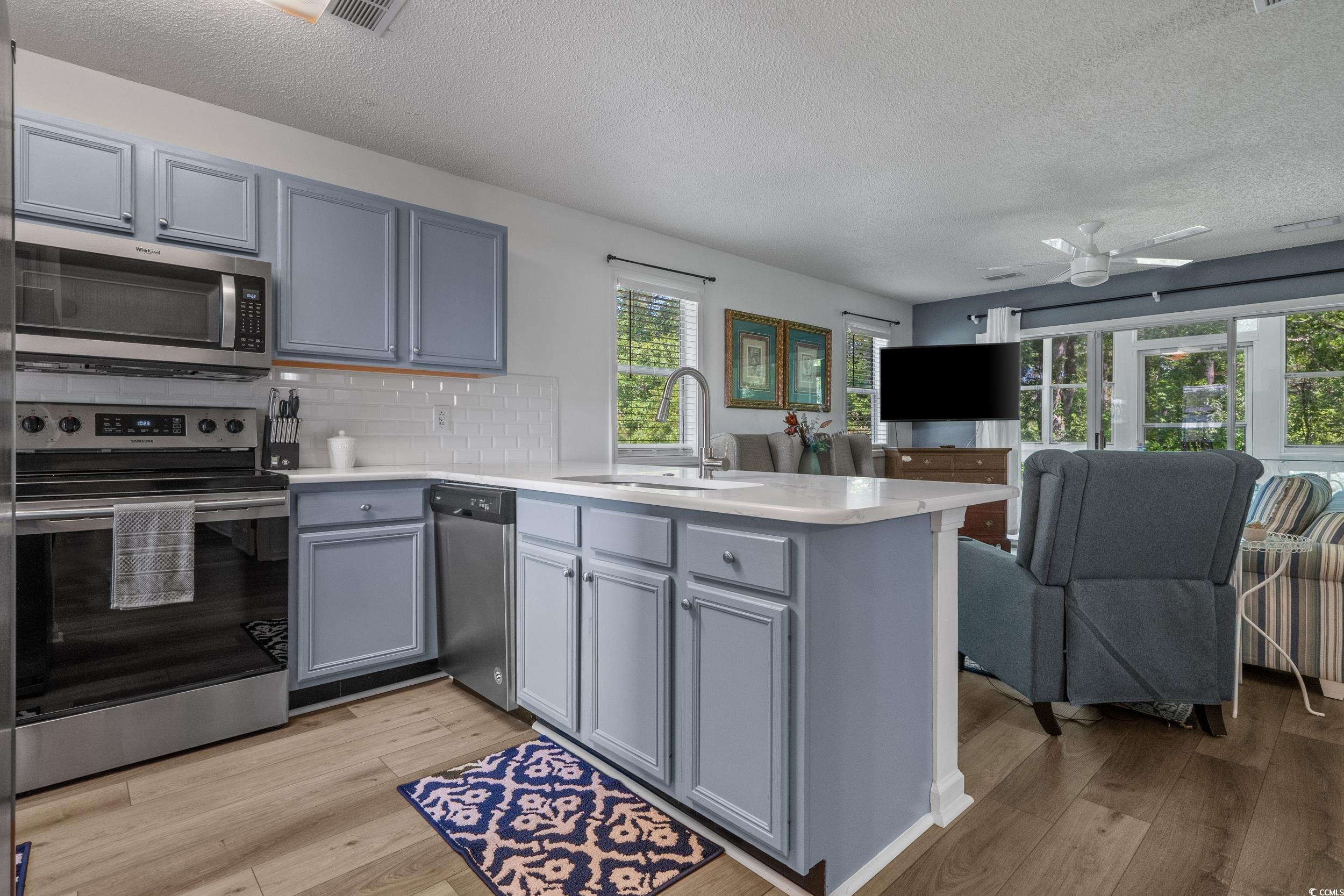 1290 White Tree Lane Myrtle Beach, SC 29588 - Photo 12 of 33 Living area with a textured ceiling, dark wood-style flooring, and a ceiling fan