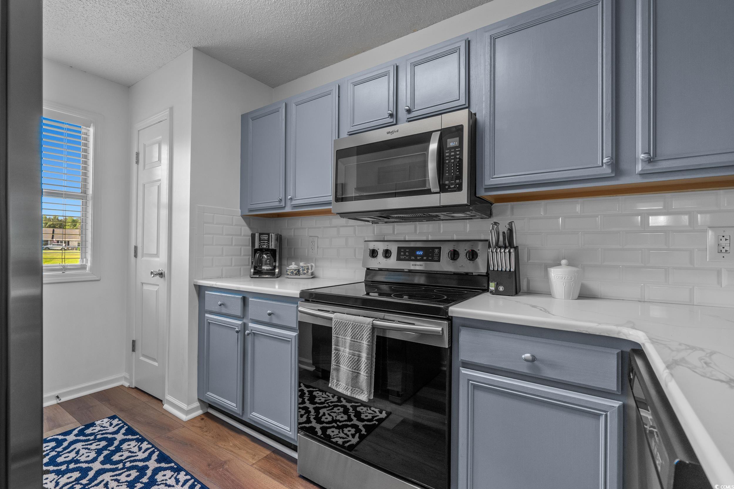 1290 White Tree Lane Myrtle Beach, SC 29588 - Photo 13 of 33 Kitchen featuring a breakfast bar, a peninsula, tasteful backsplash, stainless steel appliances, and light wood-style flooring