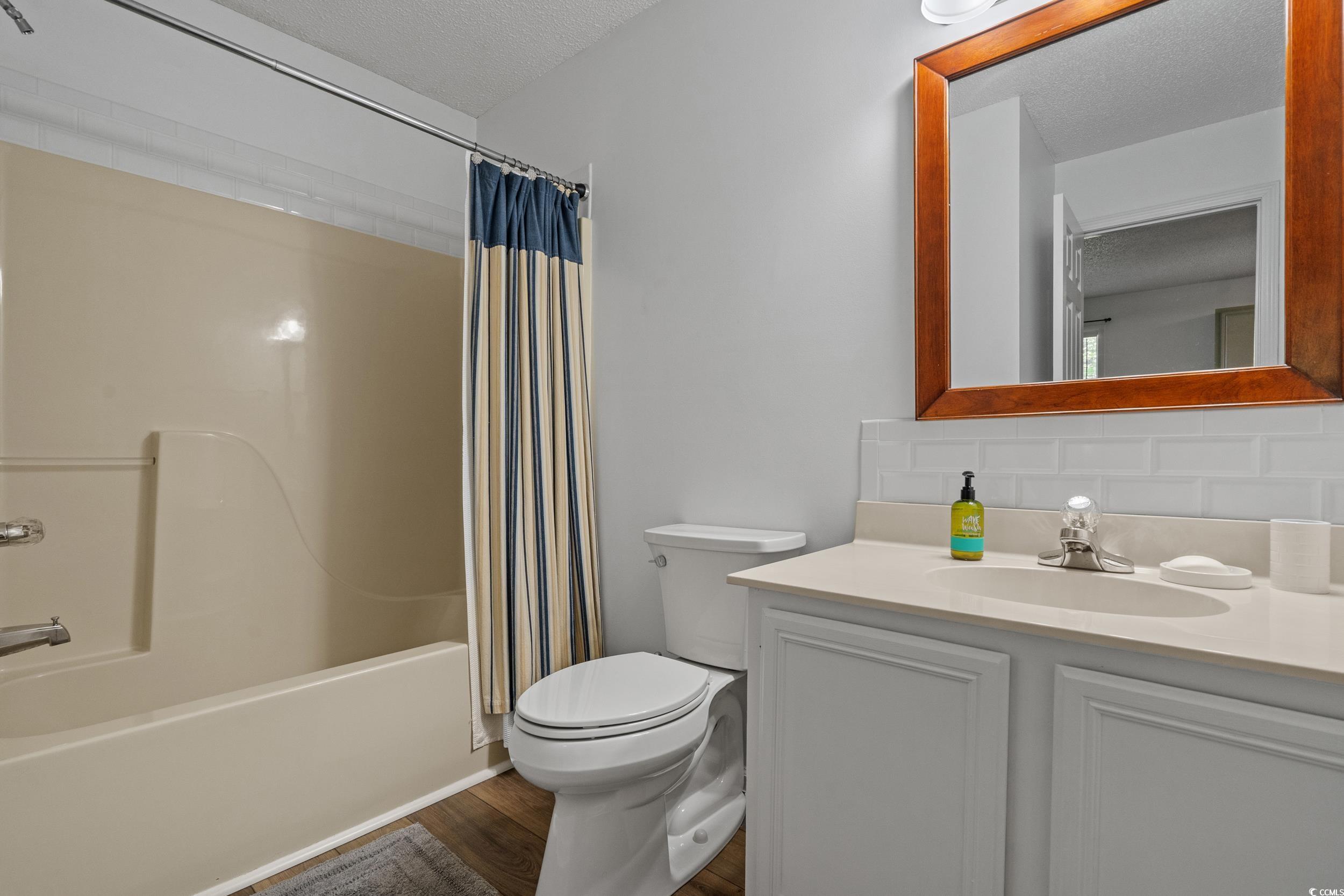 1290 White Tree Lane Myrtle Beach, SC 29588 - Photo 23 of 33 Bathroom featuring vanity, a textured ceiling, and a marble finish shower
