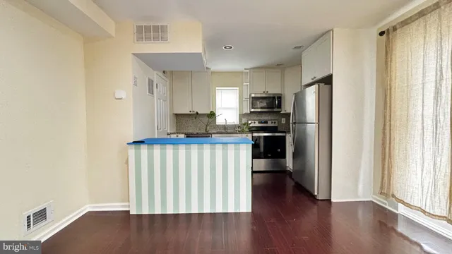 a kitchen with a refrigerator and a stove top oven