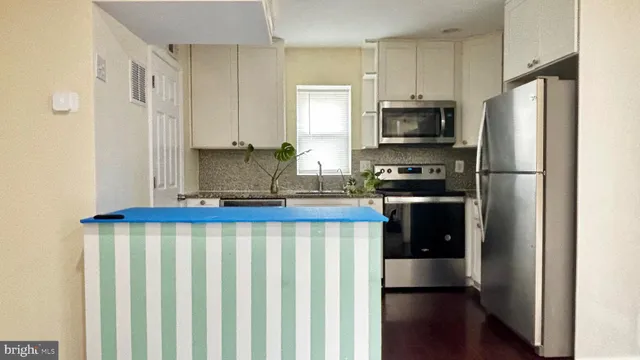 a kitchen with stainless steel appliances a refrigerator a stove a microwave and cabinets