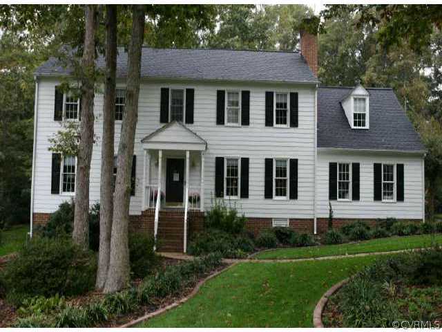 a view of a brick house with a yard and large windows