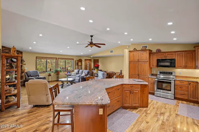 a kitchen with stainless steel appliances granite countertop a stove a sink and a microwave