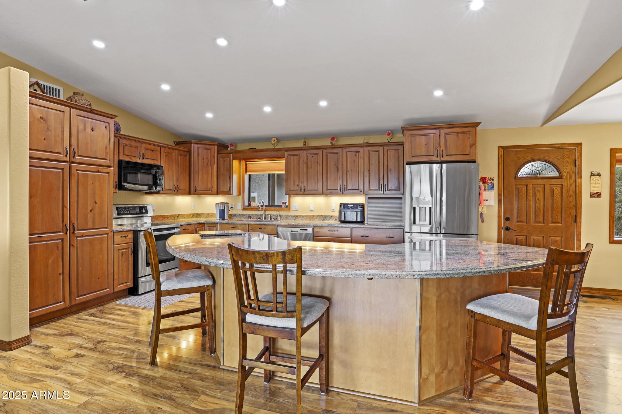 804 East Phoenix Street Payson, AZ 85541 - Photo 15 of 56 a kitchen with stainless steel appliances granite countertop a stove a refrigerator a oven a sink with a dining table and chairs