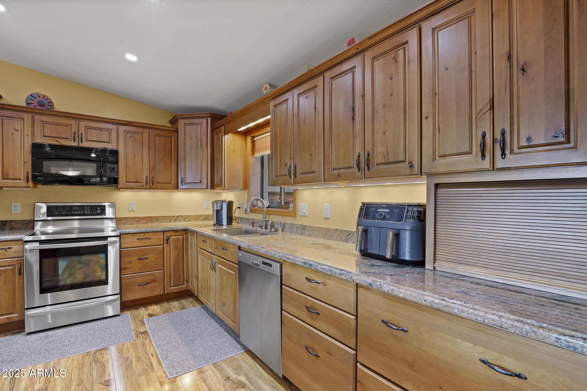 804 East Phoenix Street Payson, AZ 85541 - Photo 16 of 56 a kitchen with stainless steel appliances granite countertop a stove a sink and a microwave
