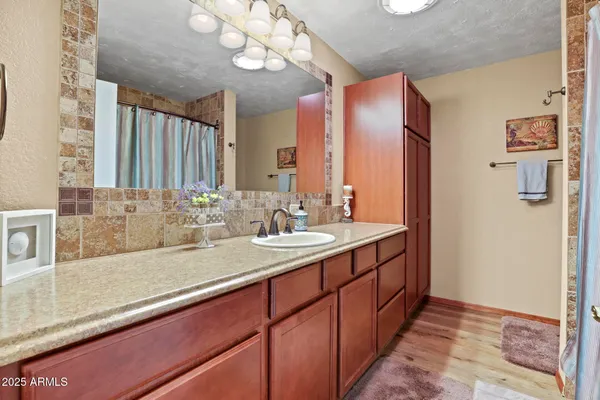 a kitchen with granite countertop a sink cabinets and wooden floor
