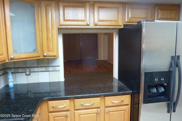 a kitchen with granite countertop a refrigerator and a sink