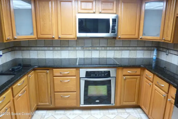 a kitchen with windows and a refrigerator