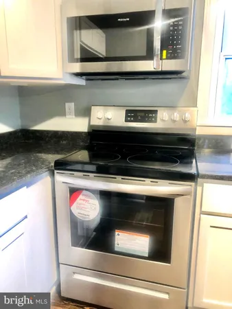 a stove top oven sitting inside of a kitchen