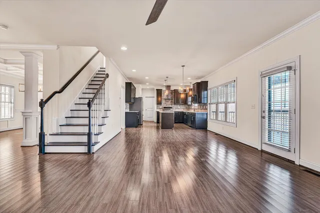 a view of a livingroom with wooden floor and staircase
