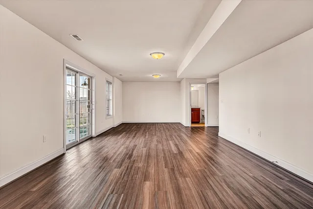 a view of an empty room with wooden floor