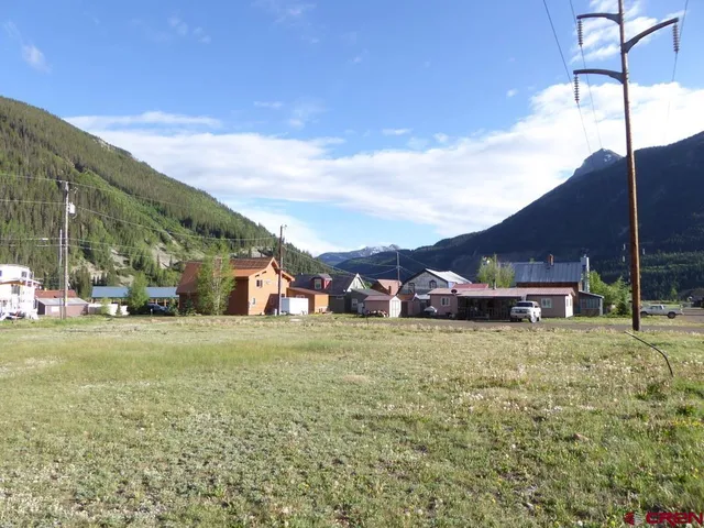 a view of a big house with a big yard and large trees