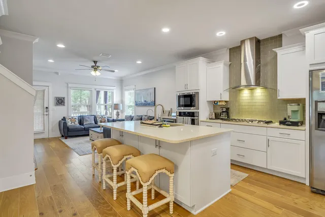 a large white kitchen with lots of counter top space and living room