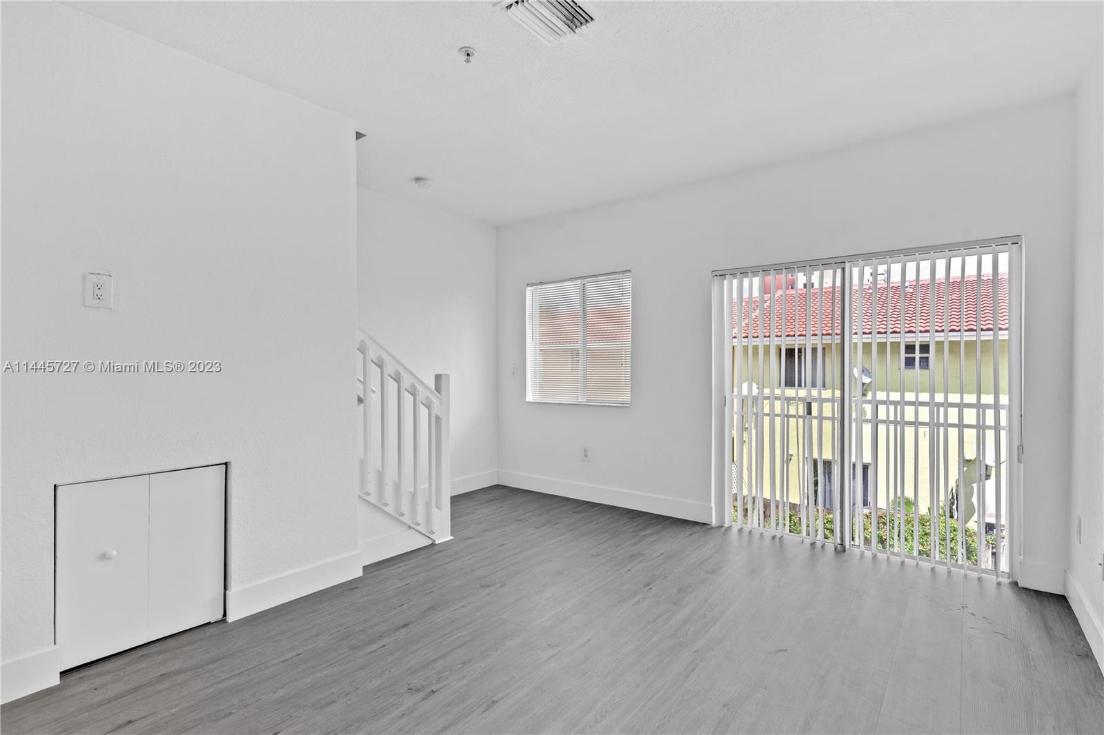7989 Northwest 8th Street, Unit 110 Miami, FL 33126 - Photo 12 of 24 an empty room with wooden floor and windows