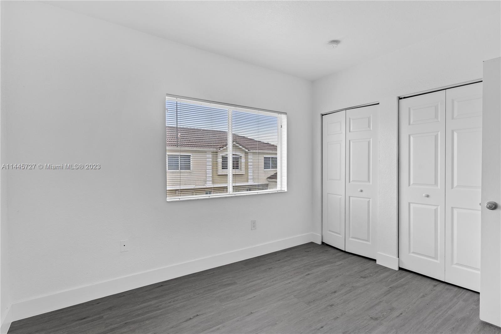 7989 Northwest 8th Street, Unit 110 Miami, FL 33126 - Photo 17 of 24 a view of an empty room with wooden floor and a window