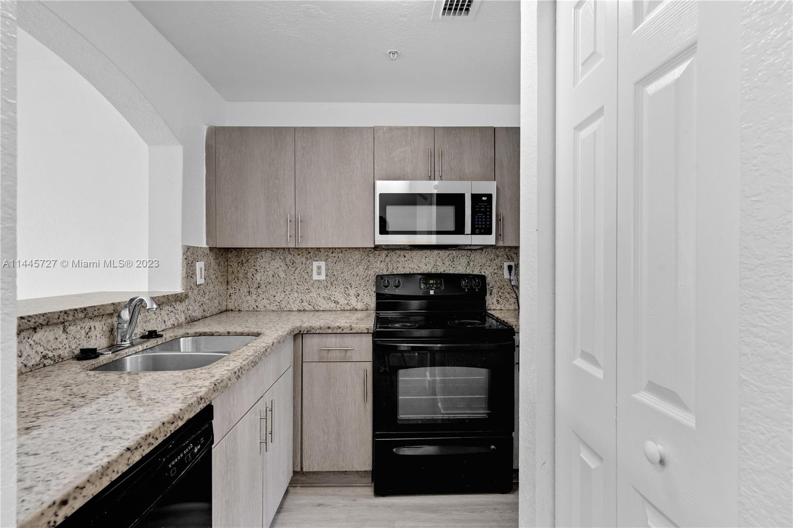 7989 Northwest 8th Street, Unit 110 Miami, FL 33126 - Photo 7 of 24 a kitchen with a sink and stainless steel appliances