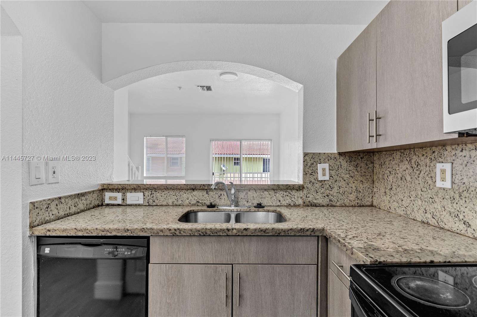 7989 Northwest 8th Street, Unit 110 Miami, FL 33126 - Photo 9 of 24 a kitchen with a sink stove and cabinets
