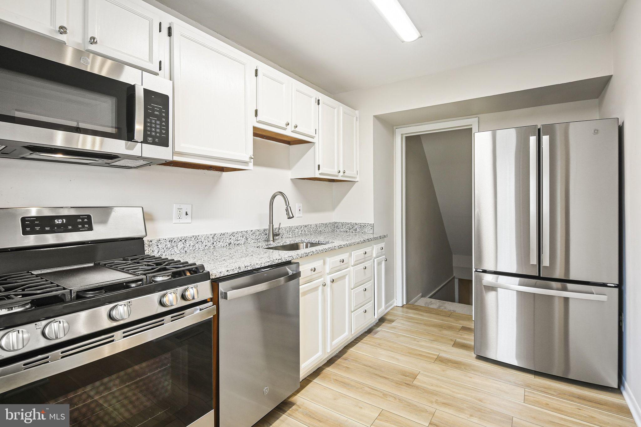 8209 Stewarton Court Severn, MD 21144 - Photo 13 of 34 a kitchen with stainless steel appliances granite countertop a stove a refrigerator and a microwave