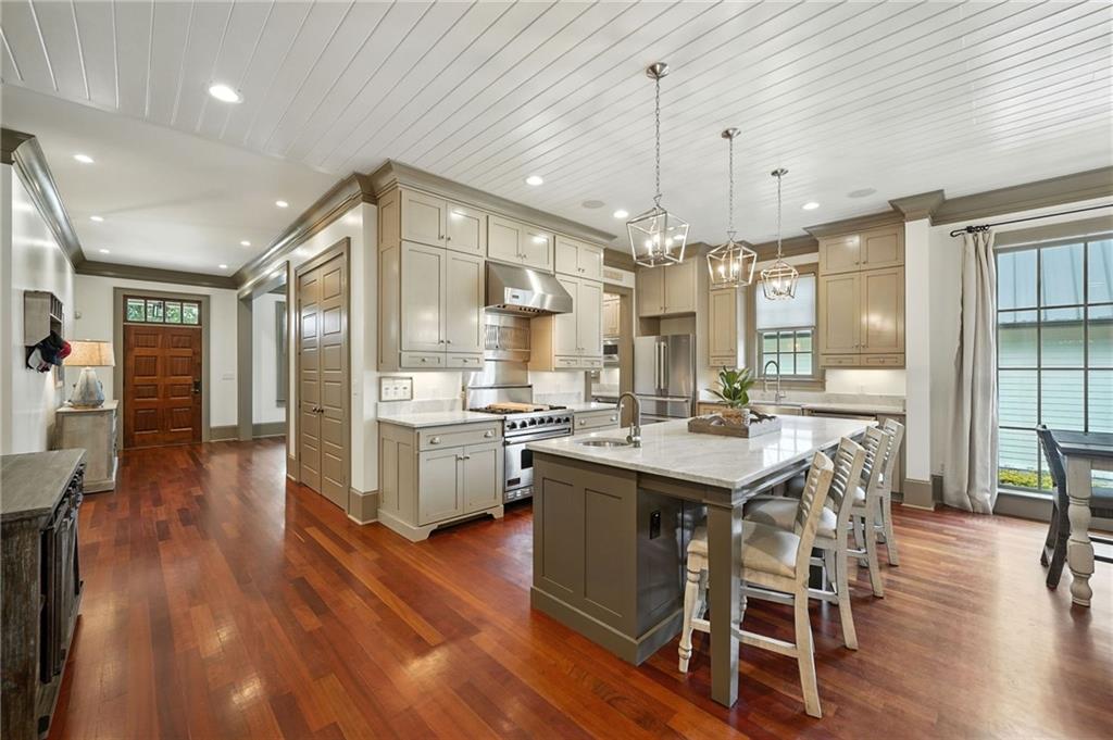 2229 Long Road Ball Ground, GA 30107 - Photo 24 of 88 a kitchen with stainless steel appliances a dining table chairs stove and wooden floor