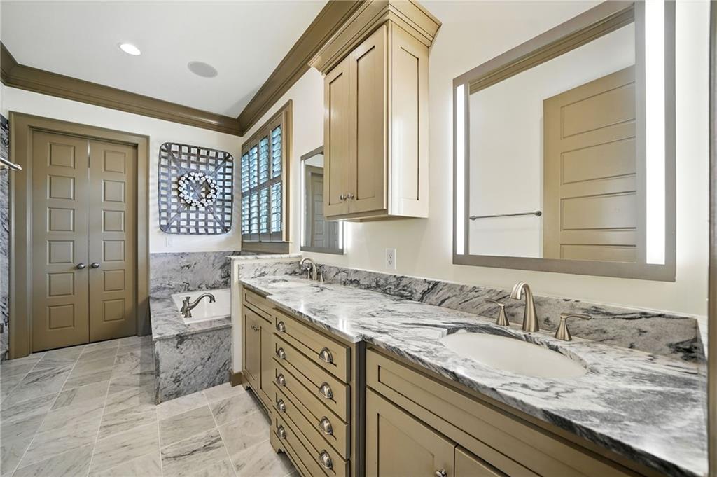 2229 Long Road Ball Ground, GA 30107 - Photo 32 of 88 a spacious bathroom with a granite countertop sink and a mirror