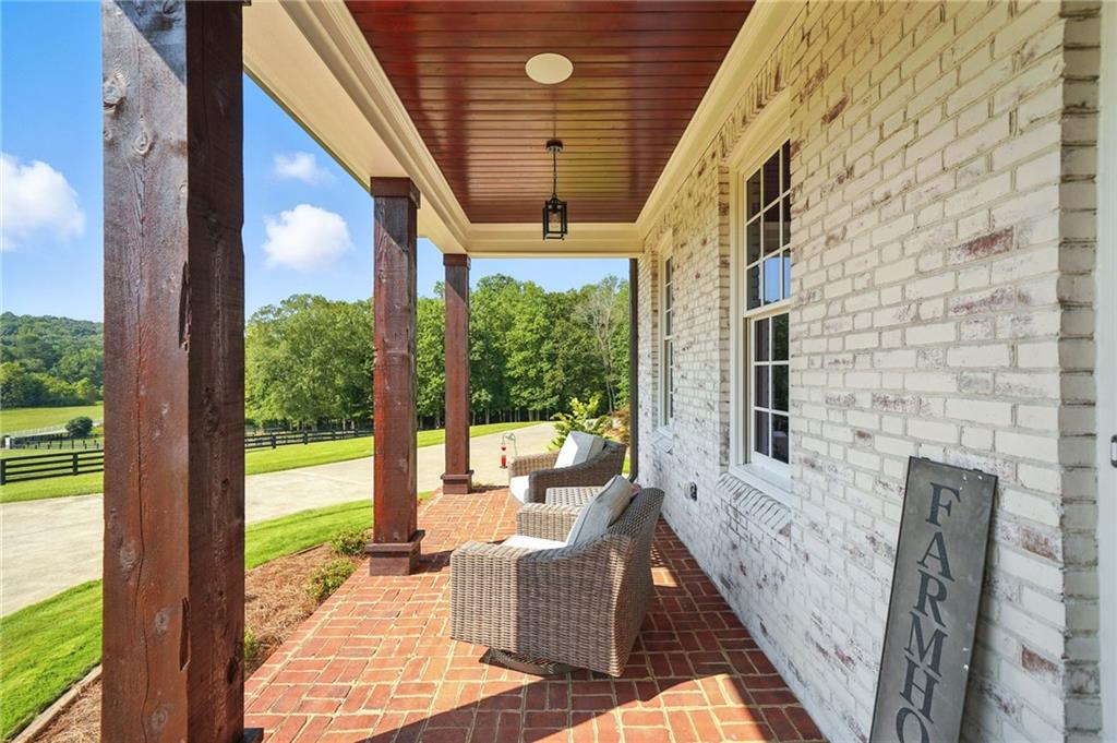 2229 Long Road Ball Ground, GA 30107 - Photo 9 of 88 a view of a patio with couches chairs potted plants and floor to ceiling window