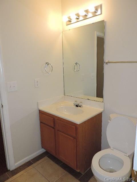 3726 Lake Road Charlotte, NC 28269 - Photo 14 of 18 a bathroom with a toilet a sink a mirror and vanity