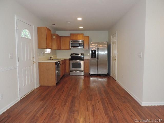 3726 Lake Road Charlotte, NC 28269 - Photo 3 of 18 a kitchen with stainless steel appliances granite countertop a refrigerator a stove top oven a sink and dishwasher with wooden floor