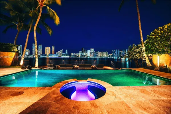 a view of a swimming pool with a lounge chairs in front of a house