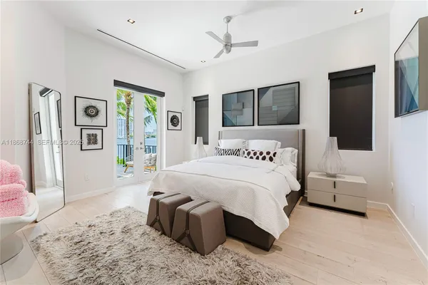 a bedroom with a bed window and mirror
