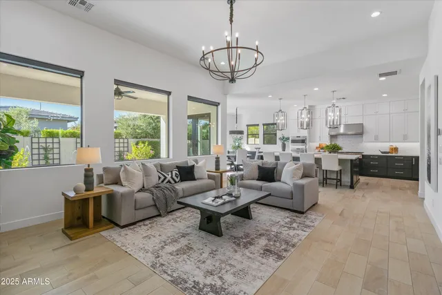 a living room with furniture a large window and a chandelier