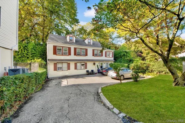 a view of a house with a yard deck and a large tree