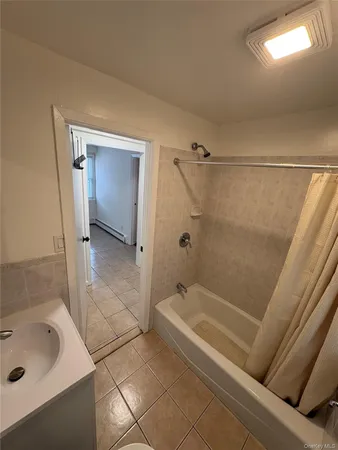 a bathroom with a tub a sink and glass door