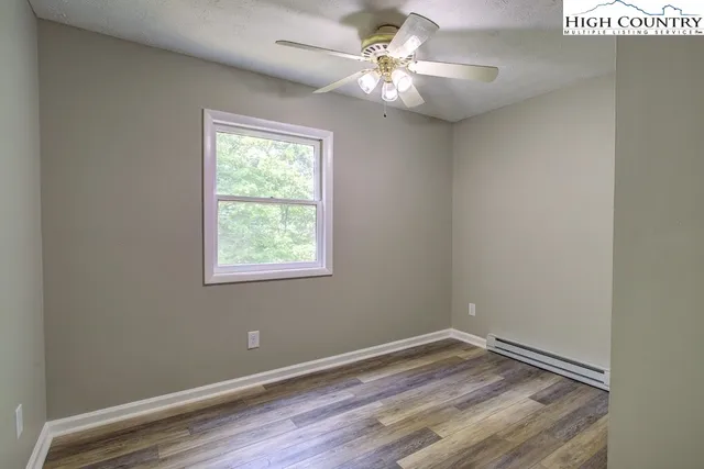 en empty room with wooden floor and window