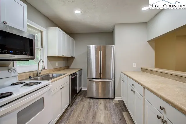 a kitchen with a sink appliances and cabinets