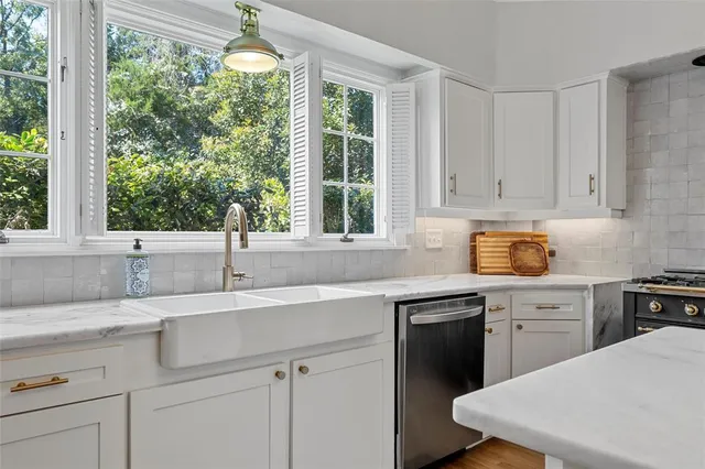 a kitchen with a sink window and cabinets