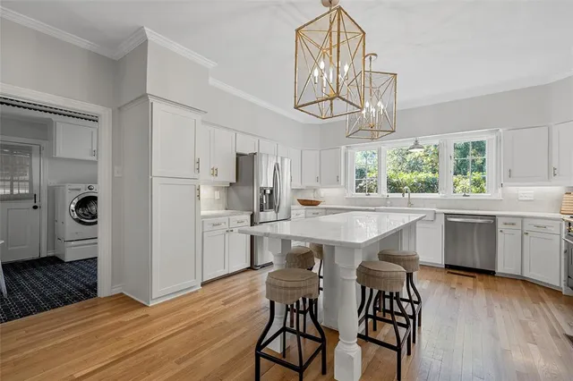 a kitchen with kitchen island a wooden floor and white appliances