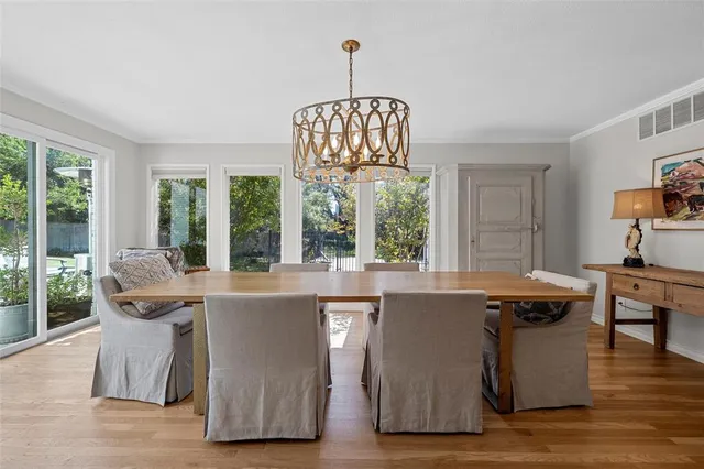 a living room with a table chairs and a chandelier