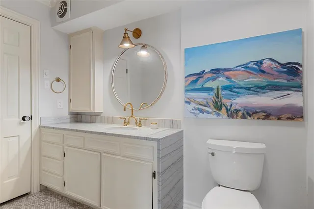 a bathroom with a toilet a sink and mirror